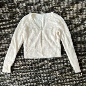 Slim-fitting short cardigan in our soft sweater with two-button placket.